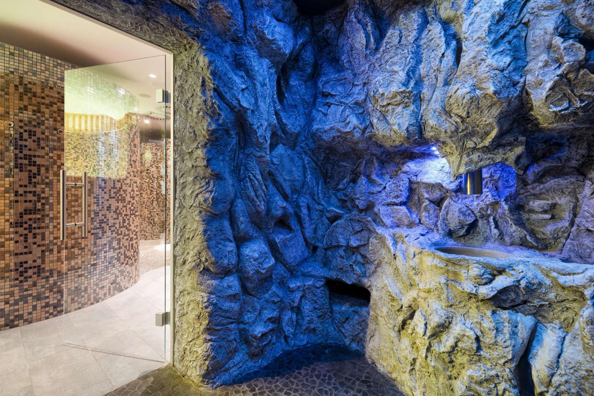 Radisson Blu Resort Świnoujście Zewnętrze zdjęcie The photo shows a spa-like environment with a cave-like design. The walls are styled to resemble natural rock formations, featuring textures and colors that suggest a stone surface. Soft blue lighting highlights the contours of the rocks, creating a 